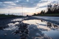 wet asphalt in the morning after dew has evaporated, with clouds and blue sky in the background