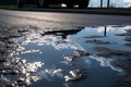 wet asphalt after rainstorm, with puddles and reflections of the sky