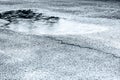 Wet asphalt sidewalk with big puddle during bad weather