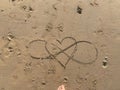 in the beach sand is painted a heart and the infinity symbol Royalty Free Stock Photo