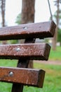 Wet bench in the park in the rain. Rainy weather. Wooden chair in the rain. Wet urban furniture. Rain drops on wooden Royalty Free Stock Photo