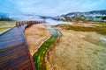 Wet boardwalks of Yellowstone over green alkaline creeks in foggy winter