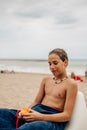 Wet boy holding apricot on the beach Royalty Free Stock Photo