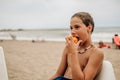 Wet boy biting apricot on the beach Royalty Free Stock Photo