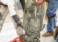 Wet cement off loaded by construction workers using a shovel from a cement truck chute into a concrete form Royalty Free Stock Photo