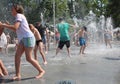 Wet cheerful people bathe in the city fountain it`s hot in summer, children laugh and splash wate
