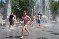 wet cheerful people bathe in the city fountain it`s hot in summer, children laugh and splash wate