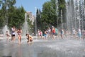 wet cheerful people bathe in the city fountain it`s hot in summer, children laugh and splash wate Royalty Free Stock Photo