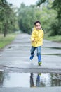 A wet child is jumping in a puddle. Fun on the street. Tempering in summer Royalty Free Stock Photo