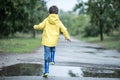 A wet child is jumping in a puddle. Fun on the street. Tempering in summer Royalty Free Stock Photo