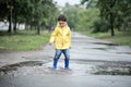 A wet child is jumping in a puddle. Fun on the street. Tempering in summer Royalty Free Stock Photo