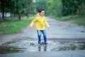 A wet child is jumping in a puddle. Fun on the street. Tempering in summer Royalty Free Stock Photo
