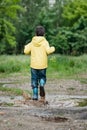 A wet child is jumping in a puddle. Fun on the street. Tempering in summer Royalty Free Stock Photo