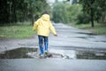 A wet child is jumping in a puddle. Fun on the street. Tempering in summer Royalty Free Stock Photo