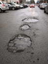 Wet city street with potholes