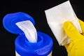 A wet cleaning cloth in a plastic container. Handkerchief with a yellow glove