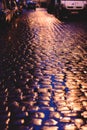 Wet cobblestone road at night. Royalty Free Stock Photo