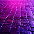 Wet cobblestones with blue reflected light at night.