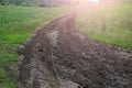 Wet dirt road leading to the village after rain. Toned background Royalty Free Stock Photo