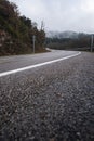 Wet empty tarmac road turn mountain track on a rainy foggy winter scene Royalty Free Stock Photo