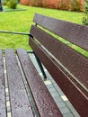 Wet empty wooden bench with rain drops in Royalty Free Stock Photo