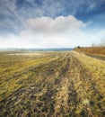 Wet farmland in early spring in Jutland, Denmark. A grassland with puddles of water against a cloudy blue sky. Landscape Royalty Free Stock Photo