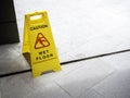 Wet floor caution sign on walkway near the building after raining. Royalty Free Stock Photo