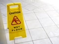 Wet floor caution sign on walkway near the building after raining. Royalty Free Stock Photo