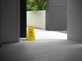 Wet floor caution sign on walkway near the building after raining. Royalty Free Stock Photo