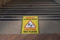 Wet floor caution sign on walkway near the building after raining. Warning yellow plastic caution wet floor sign on the Royalty Free Stock Photo