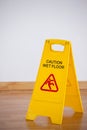 Wet floor caution sign on wooden floor