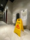 Wet floor cautious sign in male toilet at hotel