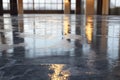 The wet floor in an industrial warehouse reflects lights at dusk Royalty Free Stock Photo