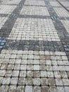 Wet footpath paved with gray and black patterned tiles Royalty Free Stock Photo