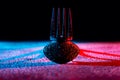 Wet fork and spoon lying on a white surface and casting blue red shadows. Empty cutlery in water droplets on black Royalty Free Stock Photo