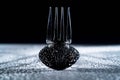 Wet fork and spoon lying on a white surface and casting shadows. Empty cutlery in water droplets on black background Royalty Free Stock Photo