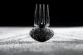 Wet fork and spoon lying on a white surface and casting shadows. Empty cutlery in water droplets on black background Royalty Free Stock Photo