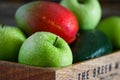 Wet fresh green fruit and vegetables in a wooden box in a kitchen. Royalty Free Stock Photo