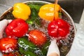 Wet fresh juicy vegetables in a metal bowl with overflowing water.