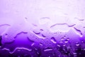Wet glass surface in drops of water, violet gradient, texture of spilled water in bright purple colors, abstract background Royalty Free Stock Photo