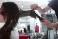 Wet hair is calculated with a comb. Hair care in a beauty salon. A woman with long, dark, matted hair. Royalty Free Stock Photo