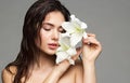 Wet Hair Woman Beauty Face Portrait. Beautiful Model Perfect Skin Make up holding Lily Flower. Brunette Girl Natural Washing Royalty Free Stock Photo