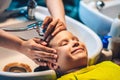 Wet Head Blond little Boy lie leaning on over sink. Woman female hands. Hair wash shower water stream, beauty Royalty Free Stock Photo