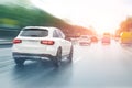 Wet highway after heavy rain with warm sunset evening sun on background. Vehicles riding with high speed by rainy city Royalty Free Stock Photo