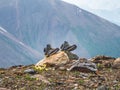 Wet hiking boots dry on a stone against the backdrop of high mountains. Difficulties of the hike Royalty Free Stock Photo