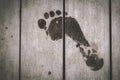 Wet human footprints on dark wooden plank floor. Walk from beach to hotel or home. Abstract backgrounds and wallpapers. Royalty Free Stock Photo