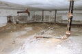 Wet littered basement with sewer pipes in an old apartment building