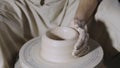 Wet male potter& x27;s hands sculpting soft clay and shaping the pot on potters wheel. Master gives shape to the pottery Royalty Free Stock Photo