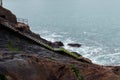 Wet and mossy stone stairs that descend between the rocks to the sea in Donostia, San Sebastian, Spain