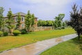 Wet path in irrigated lawn before fenced house on sunny summer d